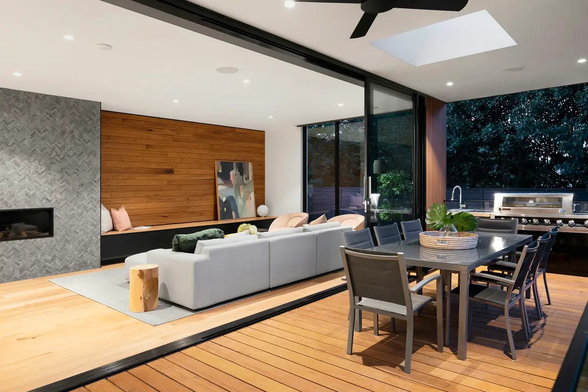 An open-plan living and dining space opening onto a deck