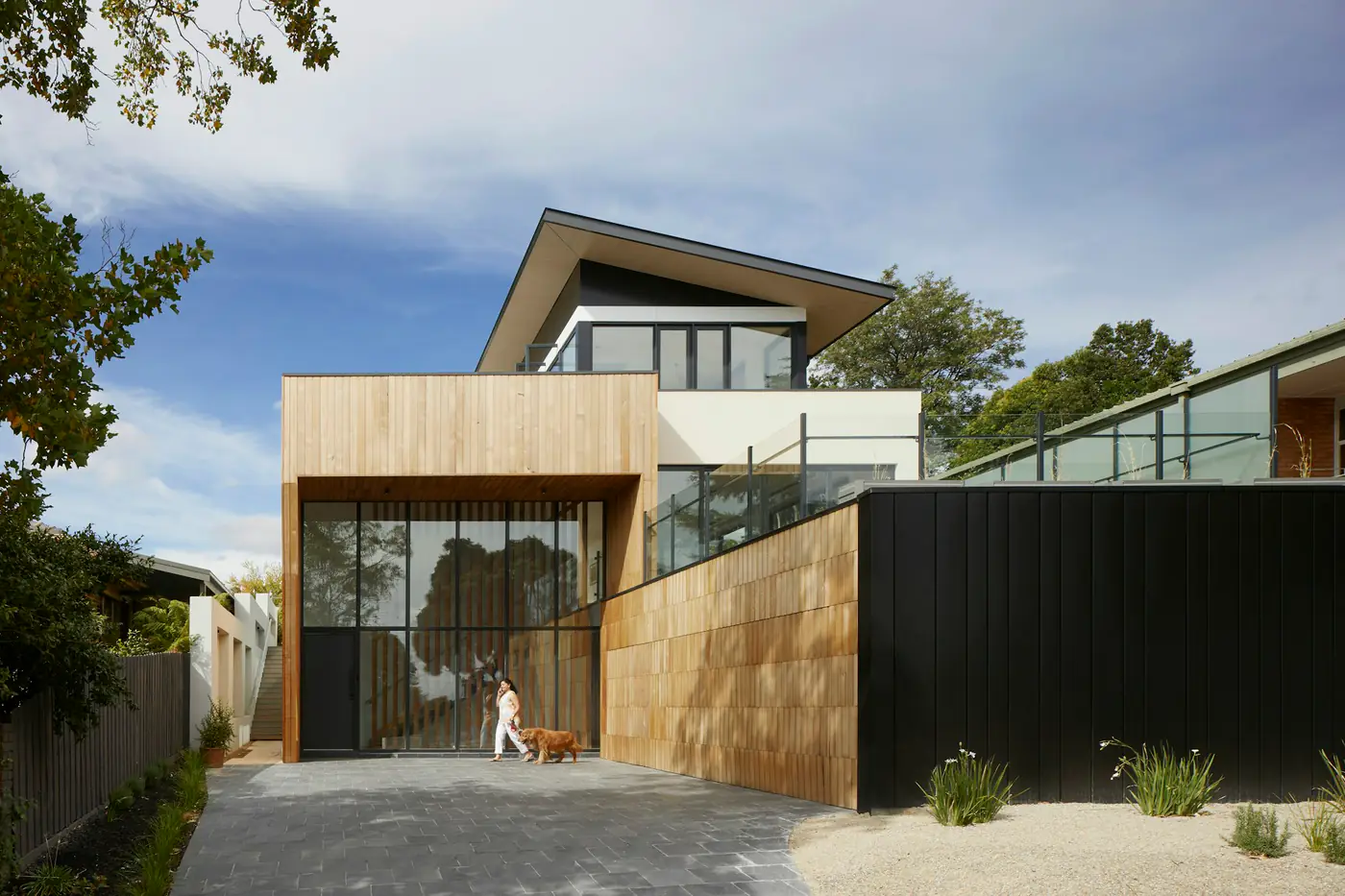 A contemporary house with timber cladding and a landscaped entrance