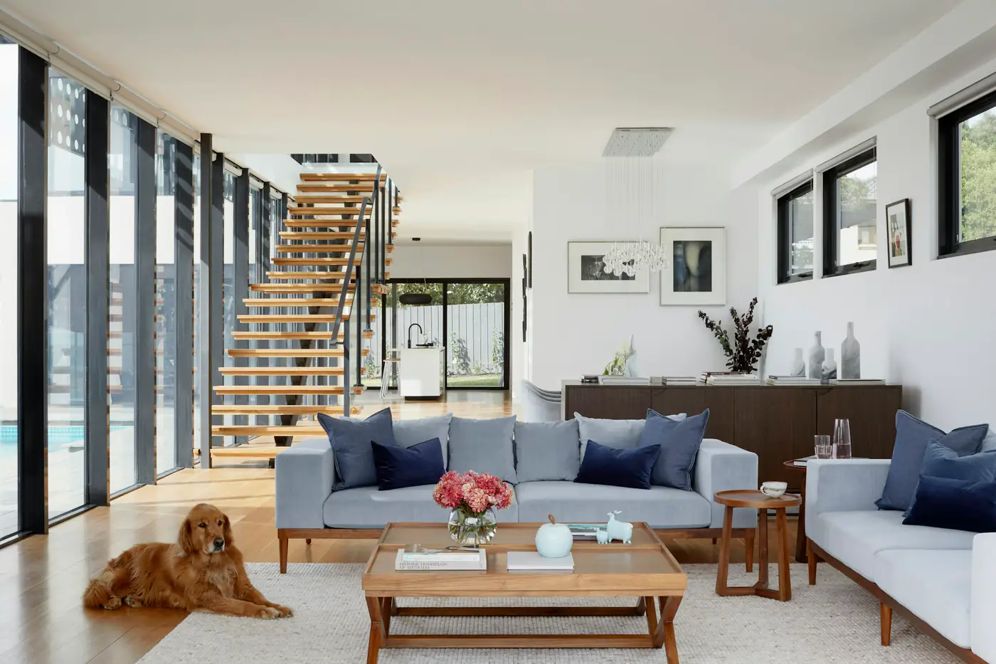 An open-plan living room with a staircase and wooden floors